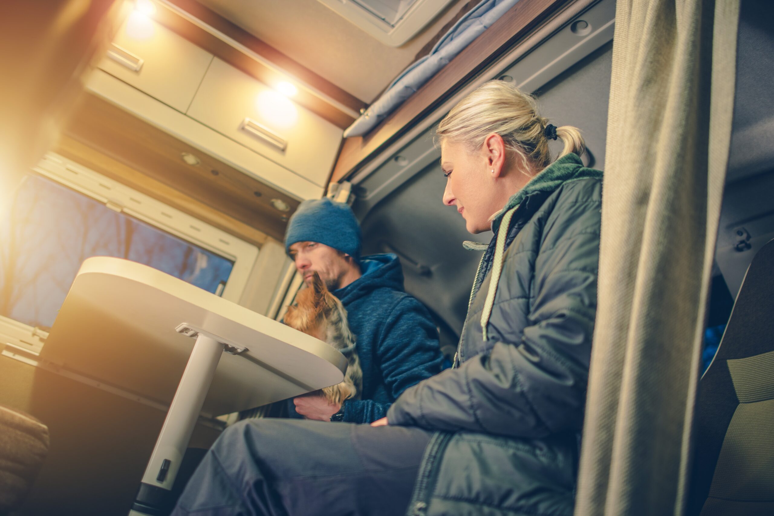 Young Couples in RV Camper Preparing For the Next Day of Drive Taking Look on the Local Map.