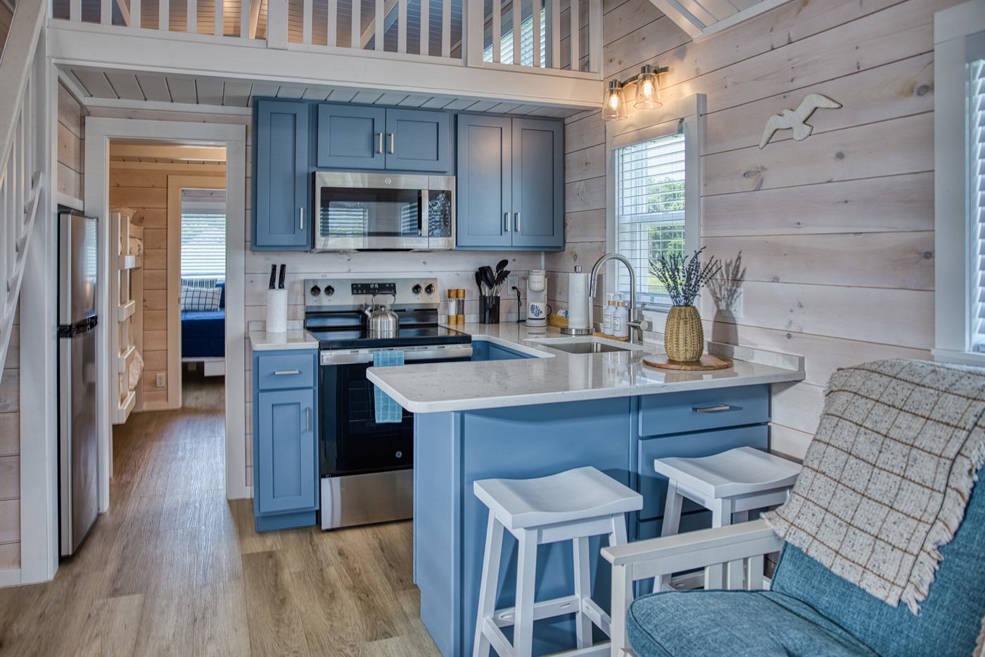 Park model kitchen and living area with blue cabinetry